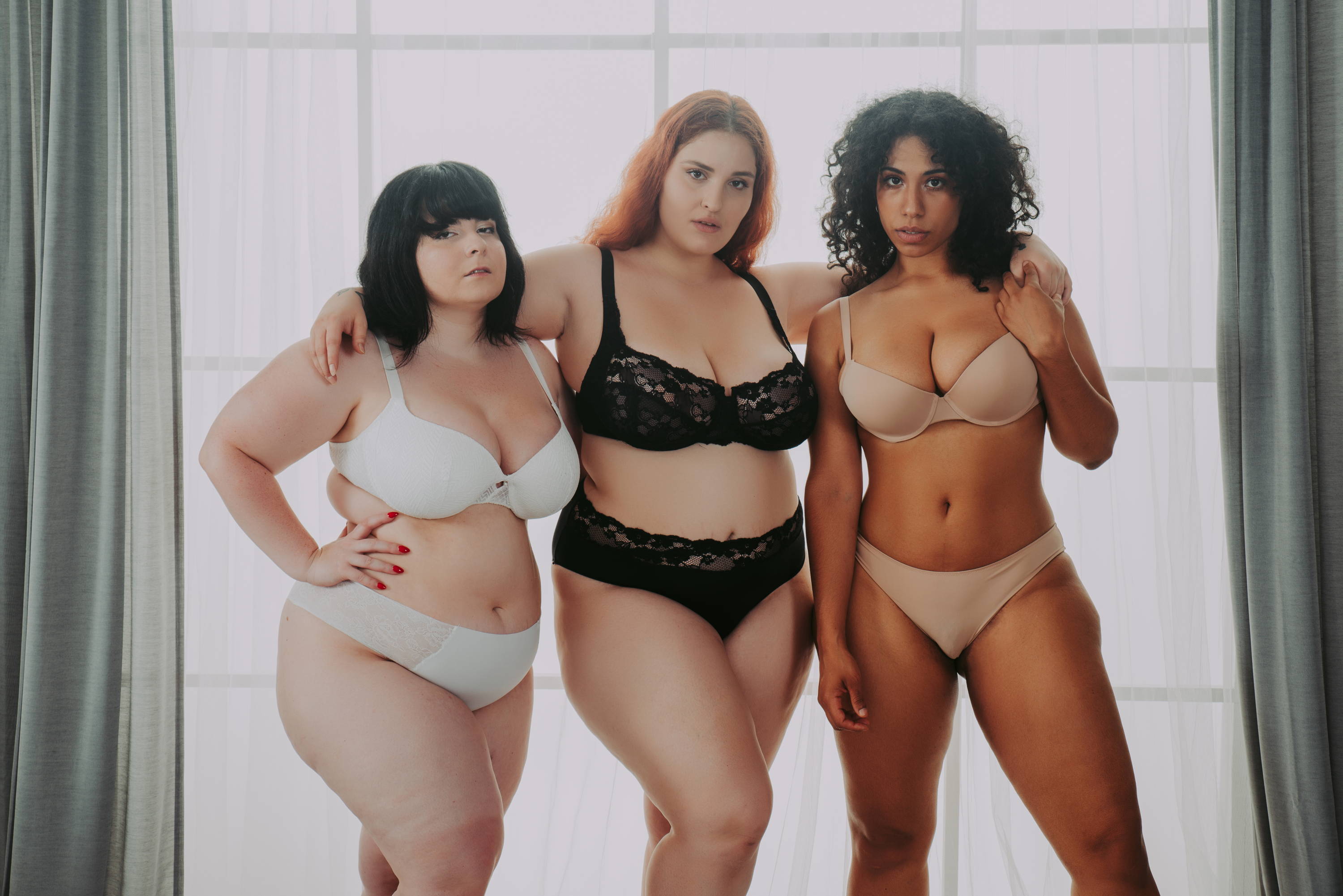 3 women in lingerie sets posing for a photo