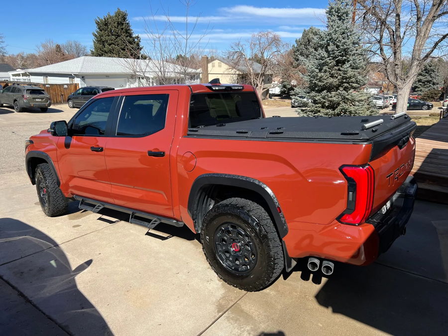Rear three-quarter driver side orange TRD Pro TRD PRO tailgate camo flares dual exhaust Falken tires Brandon's K5LA 544 install gallery photo 2
