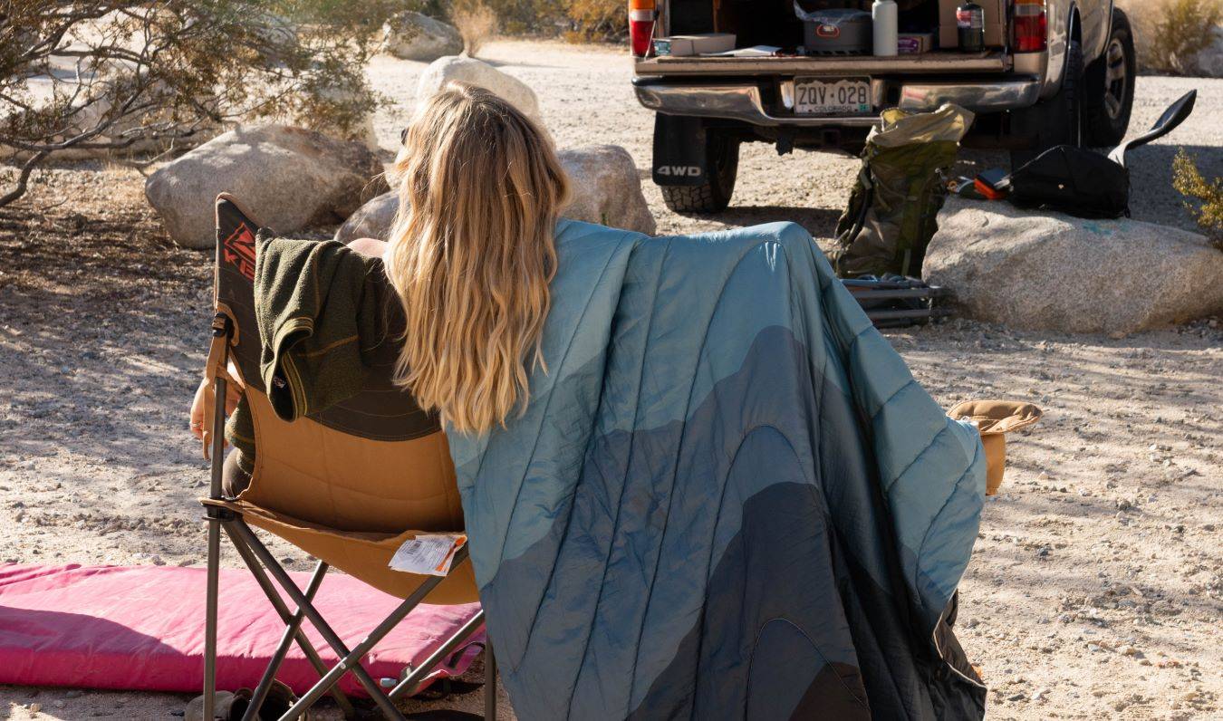 Two people sitting next to each other on camping chairs