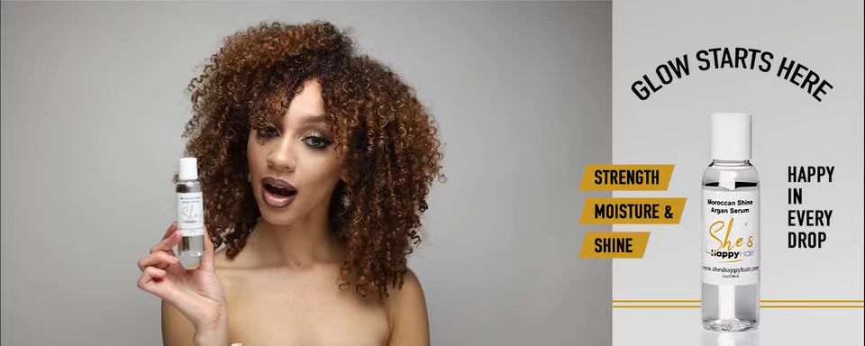 Split ad image. Left: a woman with curly, balayage-highlighted hair holds a small serum bottle near her face. Right: a bottle of She's Happy Hair Moroccan Shine Argan Serum with the text 'Glow Starts Here' and labels for strength, moisture, and shine. There is text to the right of the serum bottle reading 'Happy in Every Drop