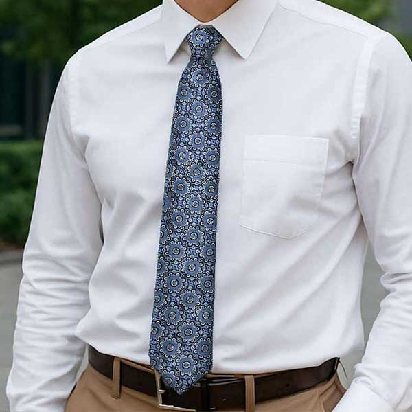 Professional man wearing a subdued blue abstract floral tie with a white dress shirt