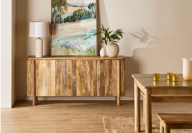 Wooden furniture with a lamp, vase, and a painting on the wall.