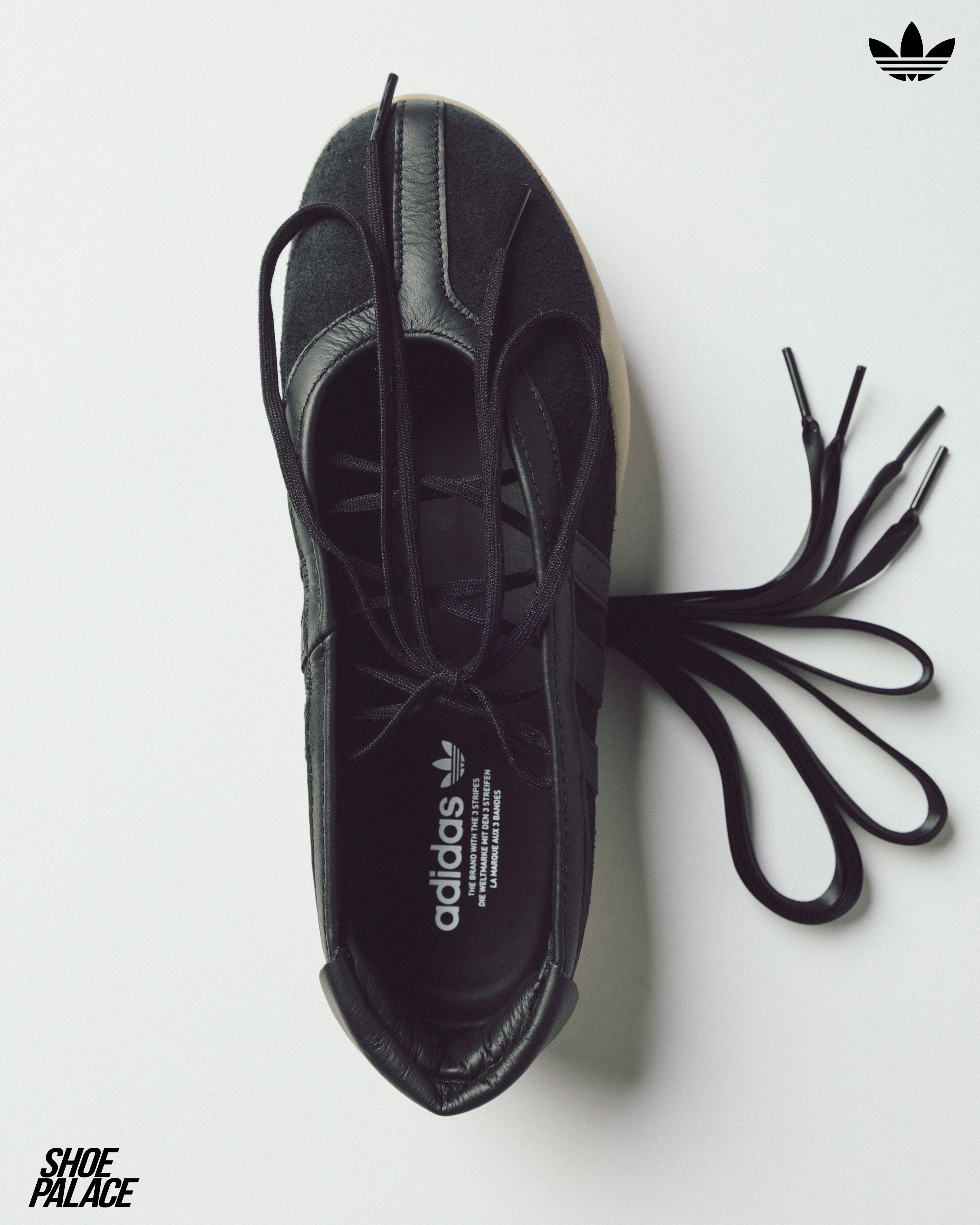 A top view of a black Adidas shoe with laces.