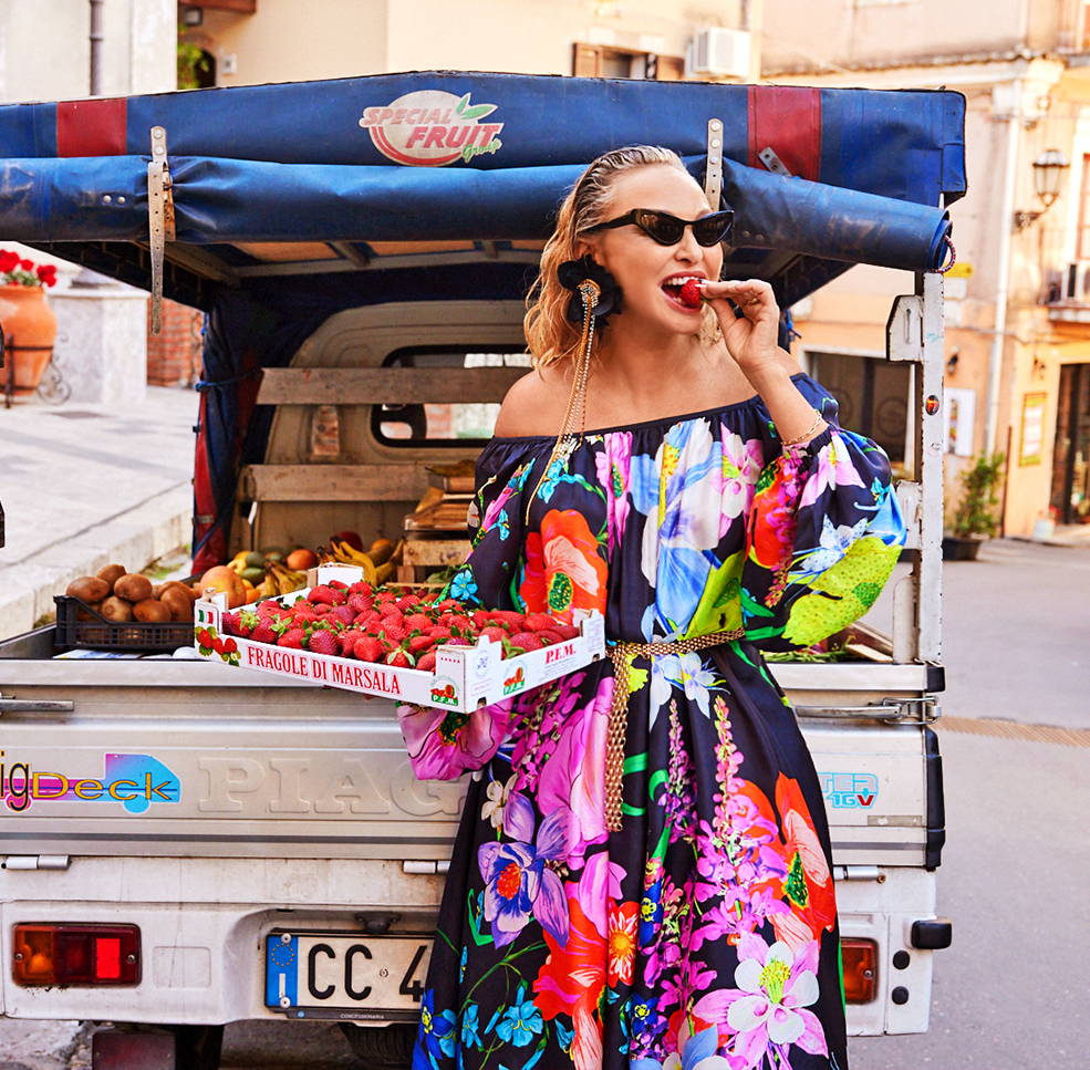 Camilla Frank's Travel Diaries: Taormina, Sicily. Image of Camilla Franks eating strawberries wearing black floral printed dress.