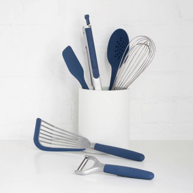 Blue Misen Prep Tools arranged in a white Prep Tool Holder, with a blue Peeler and Fish Spatula laying on the counter nearby.