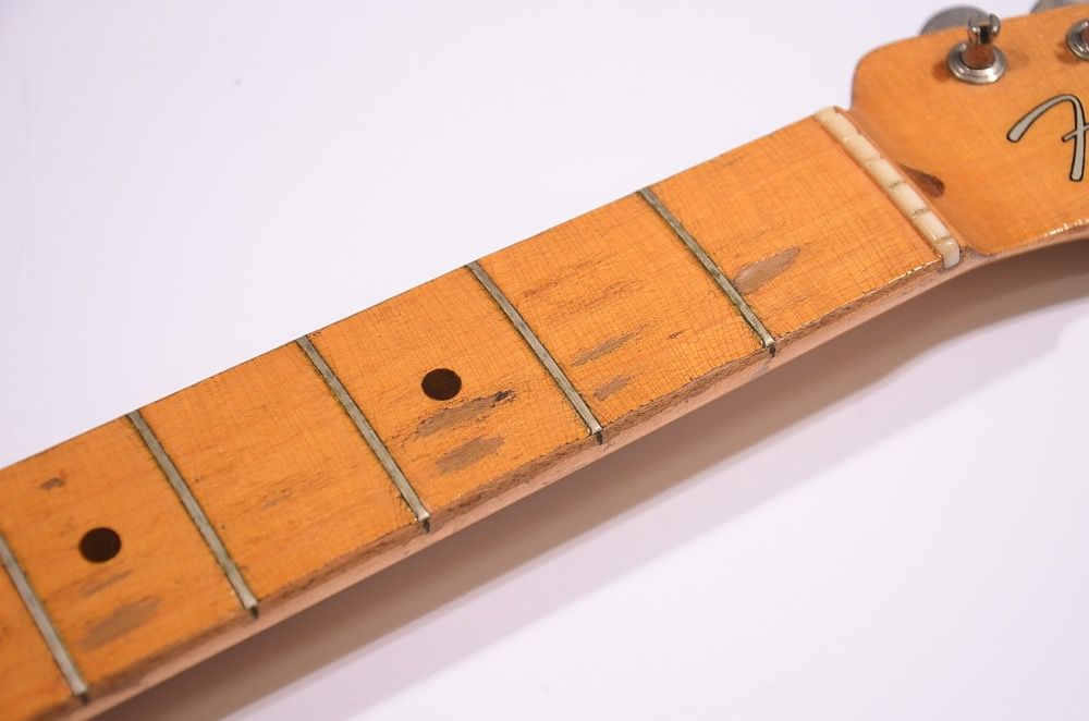 Close-up of a guitar neck with visible frets and markers.