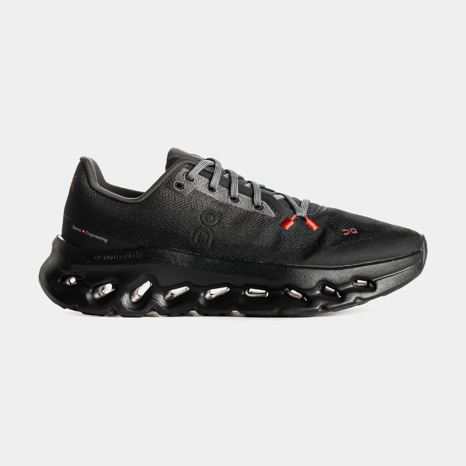 Black athletic shoe with a unique sole design and red accents.