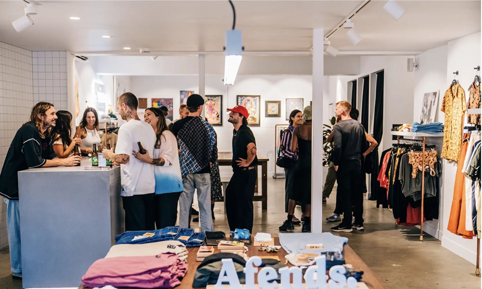 A busy clothing store with customers and staff interacting.