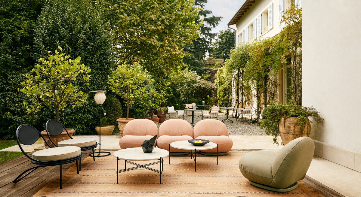 Outdoor seating area with modern furniture and lush greenery.