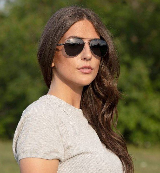 Femme portant Leo, lunettes de soleil polarisées aviateur noires pour femmes