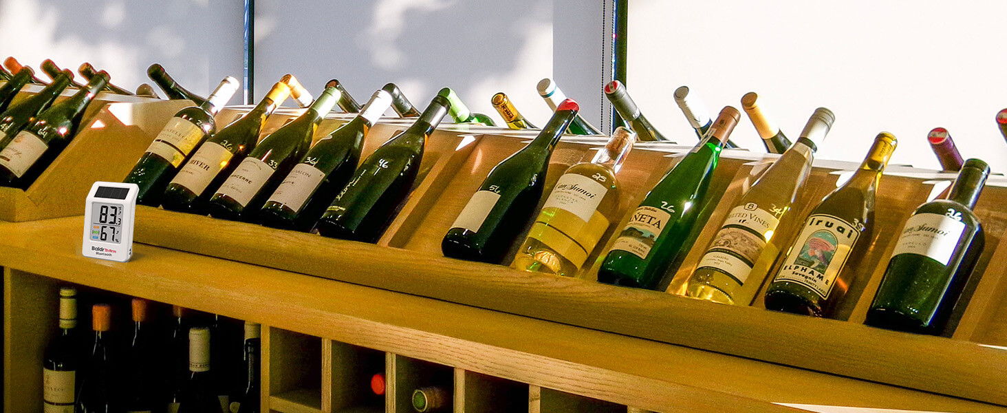 Wine bottles displayed on a wooden rack in a store.