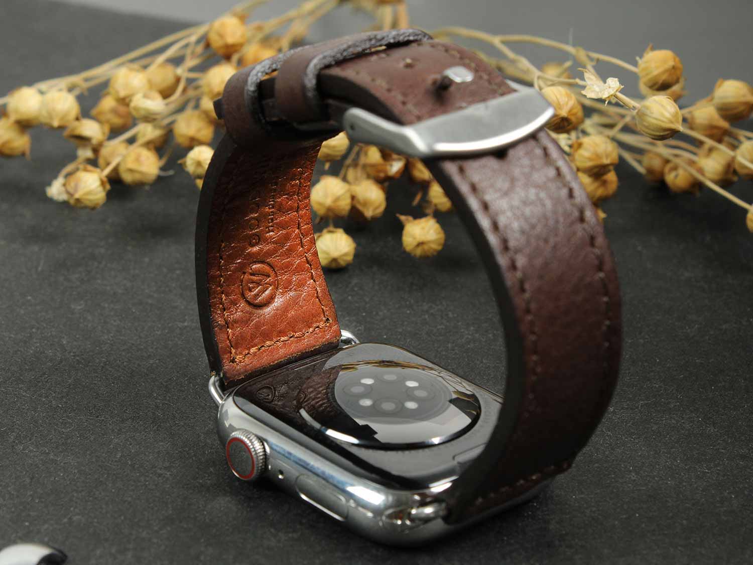 Auf einem Tisch liegt eine Apple Watch mit einem Lederarmband von Goodwilhelm in der Farbe Chocolate