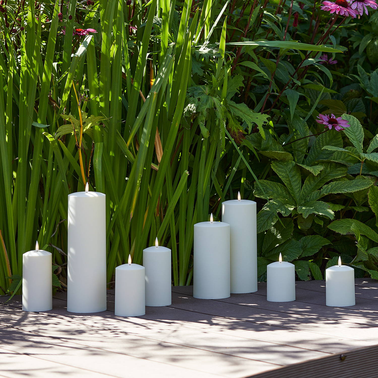 Assortment of outdoor TruGlow candles displayed on floor