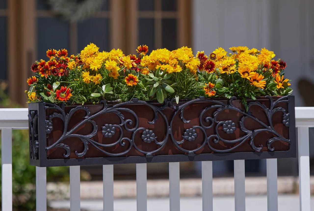French Quarter aluminum window box on a railing with orange and yellow flowers