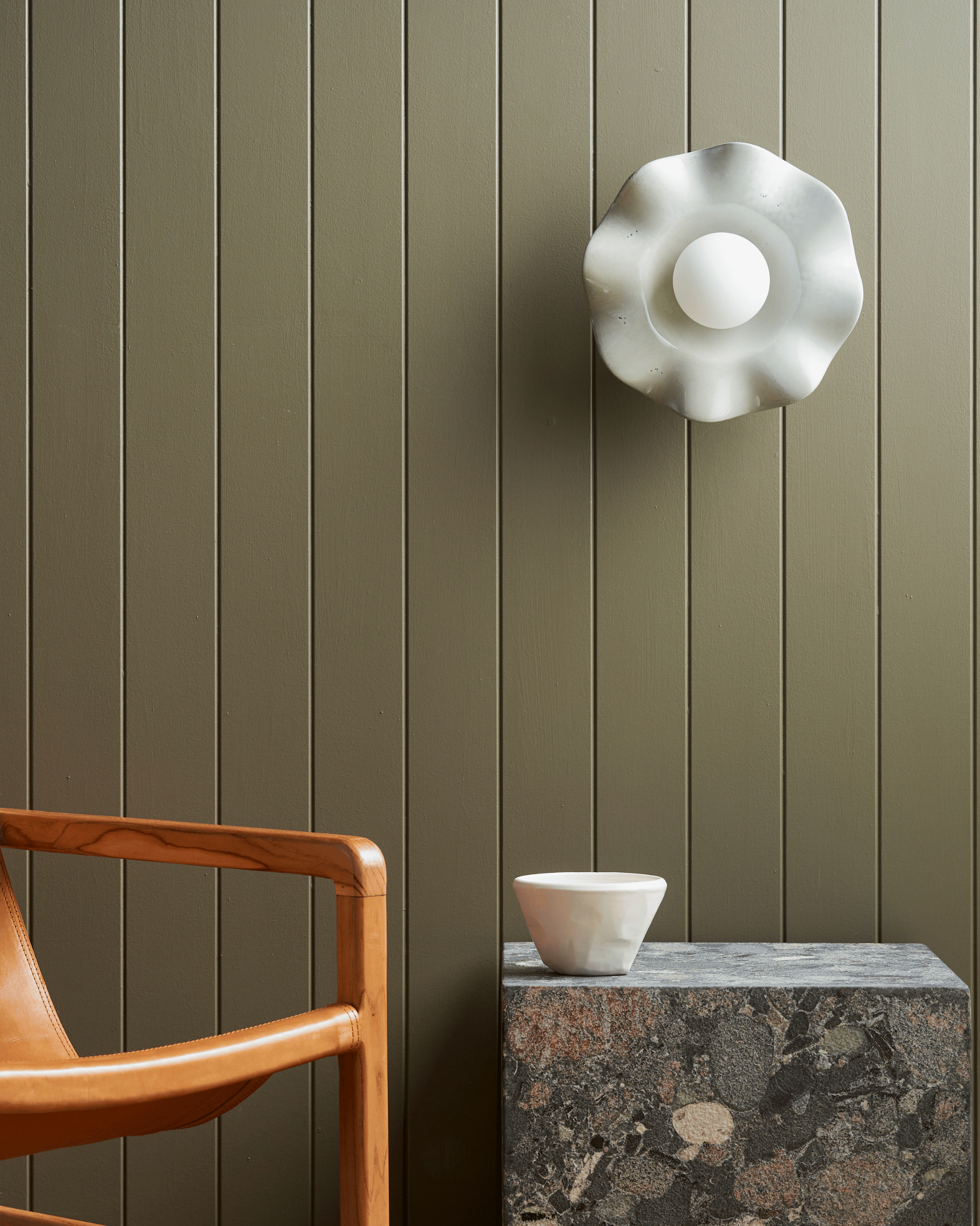 green panel wall with decorative wall sconce on it