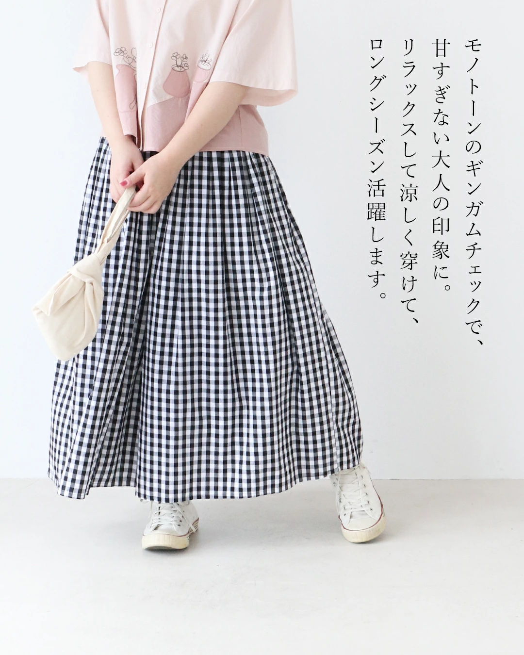 A person wearing a pink top and a checkered skirt.