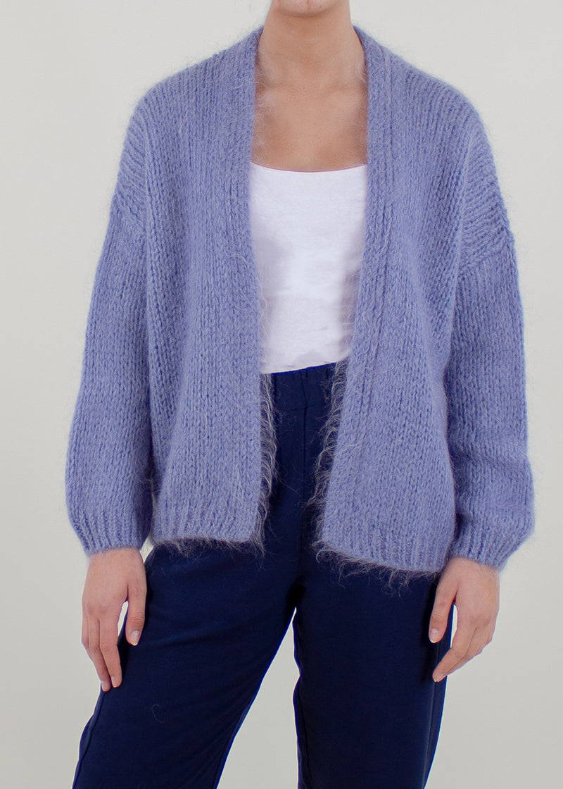 A model wearing a purple chunky cardigan