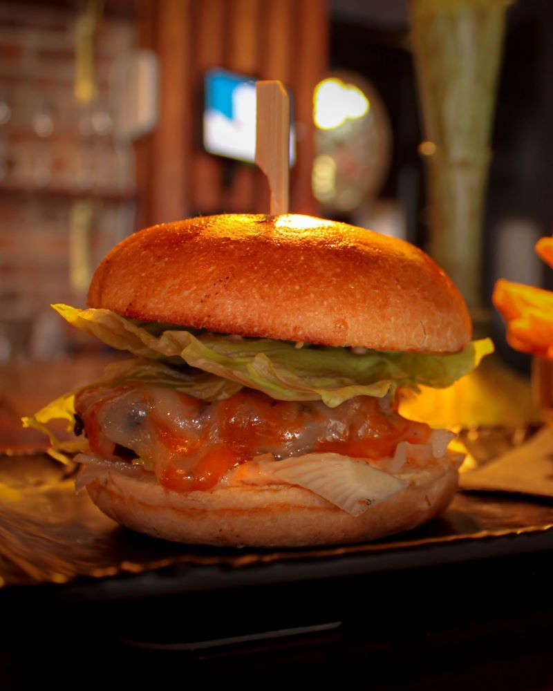 A close-up of a delicious burger with lettuce and sauce.