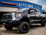 Front three-quarter dark metallic Tundra winch bumper four LED lights lifted off-road tires fender flares AUTO MAN Automotive Christie Stealth spare tire delete gallery photo 2