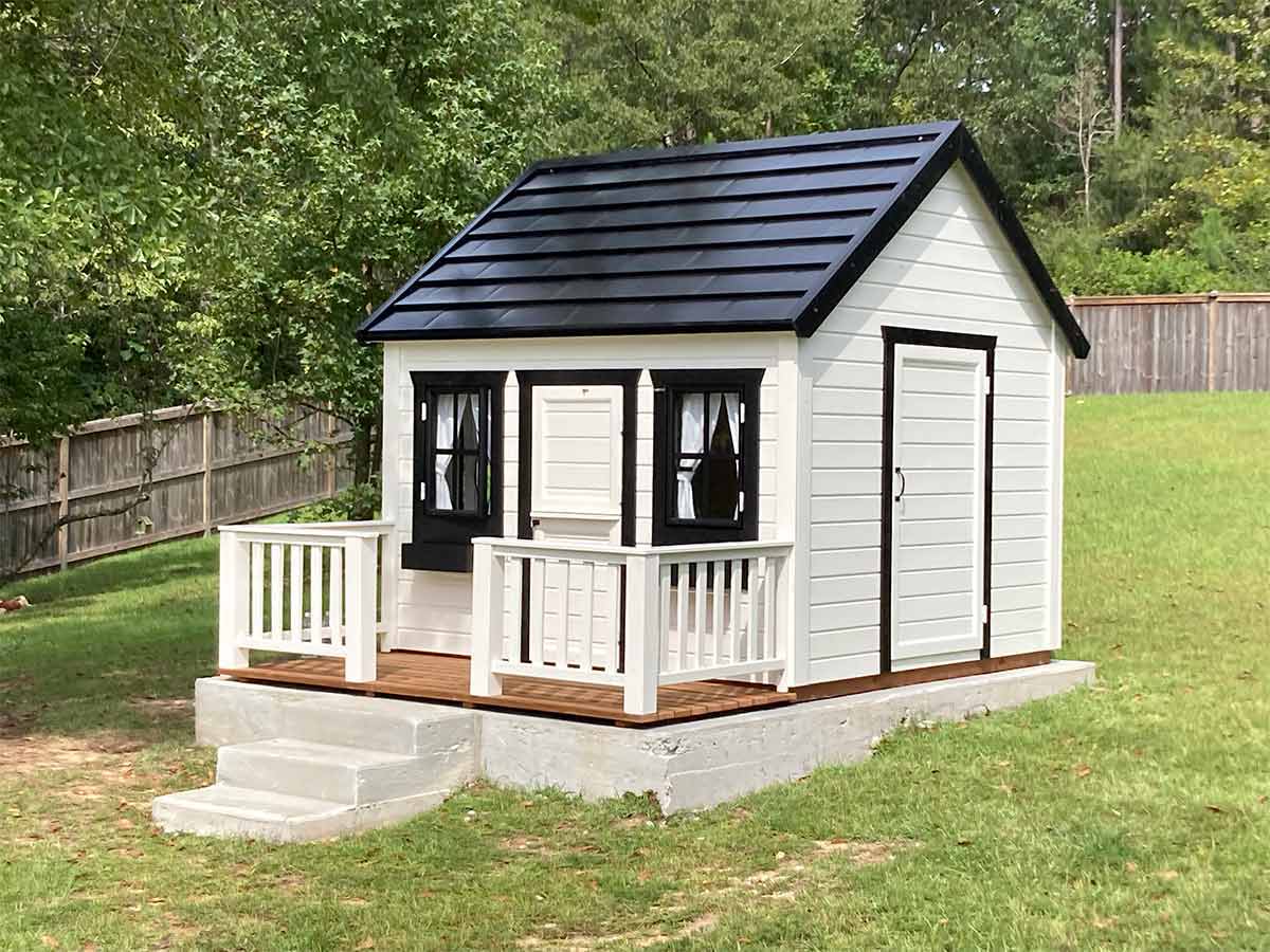 Kids Outdoor Playhouse Blackbird with Black Roof, Wooden Terrace and White Railing on the green lawn by WholeWoodPlayhouses