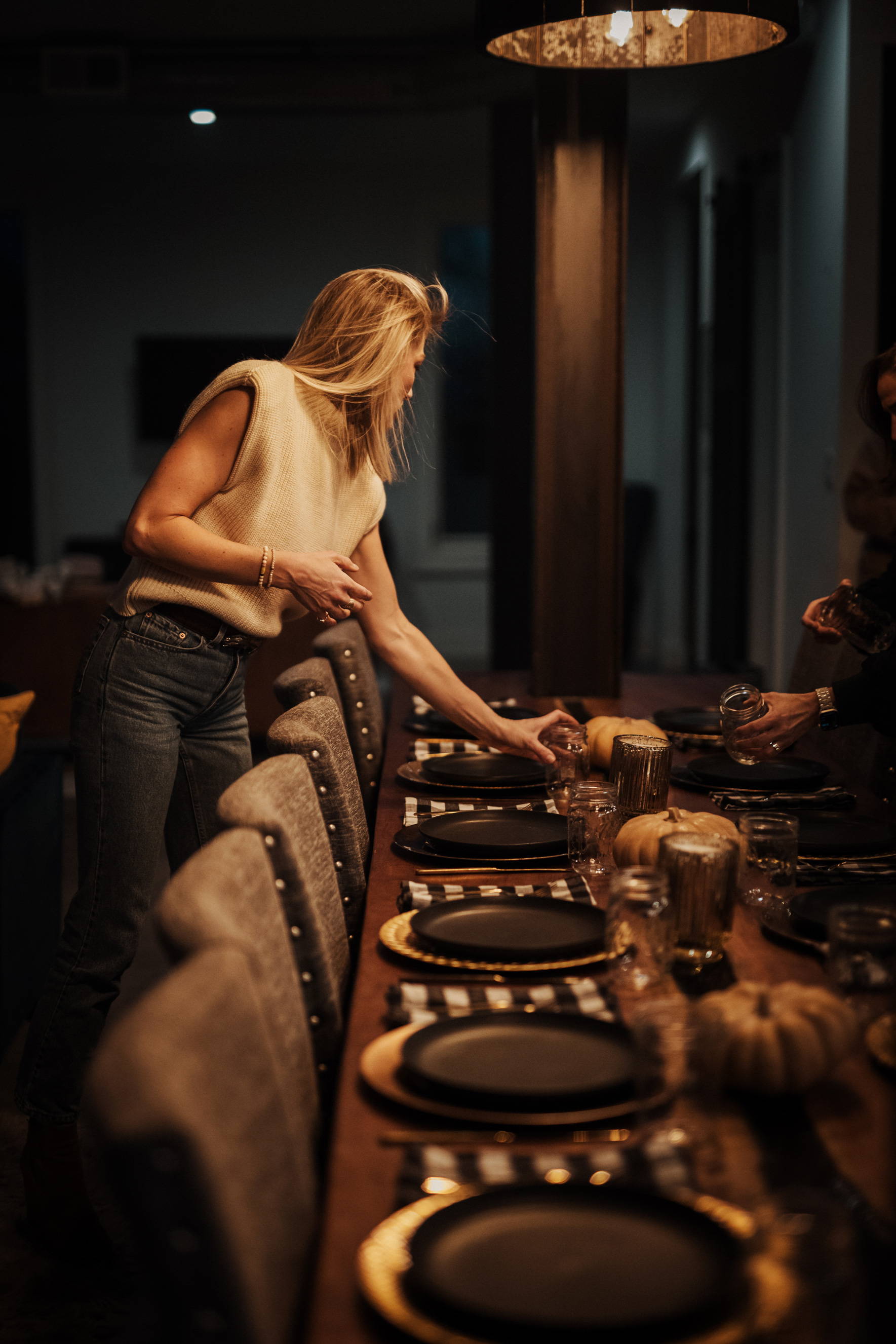 A woman setting a dinner table.