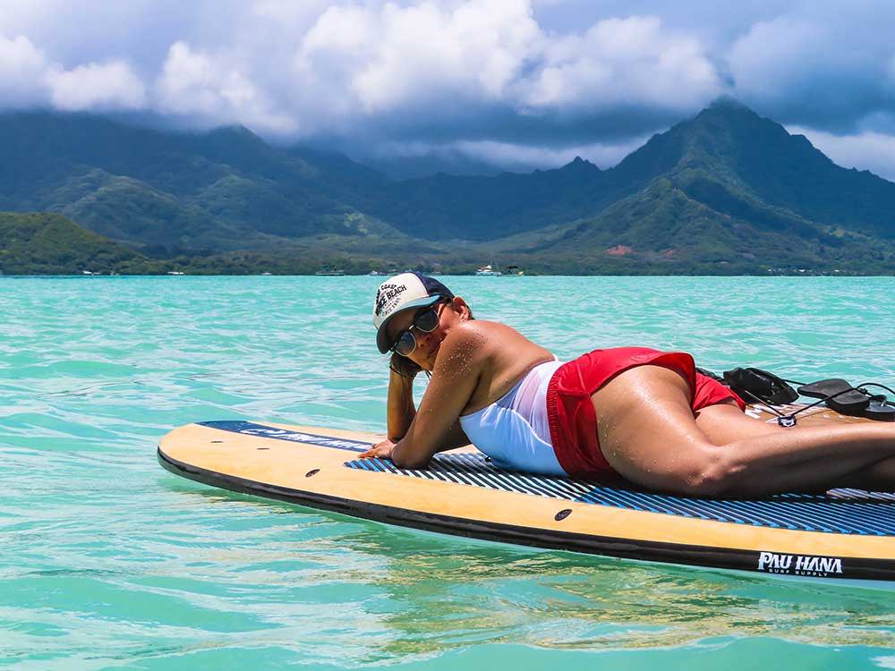 woman lying on the pau hana big ez hawaiian vft paddleboard