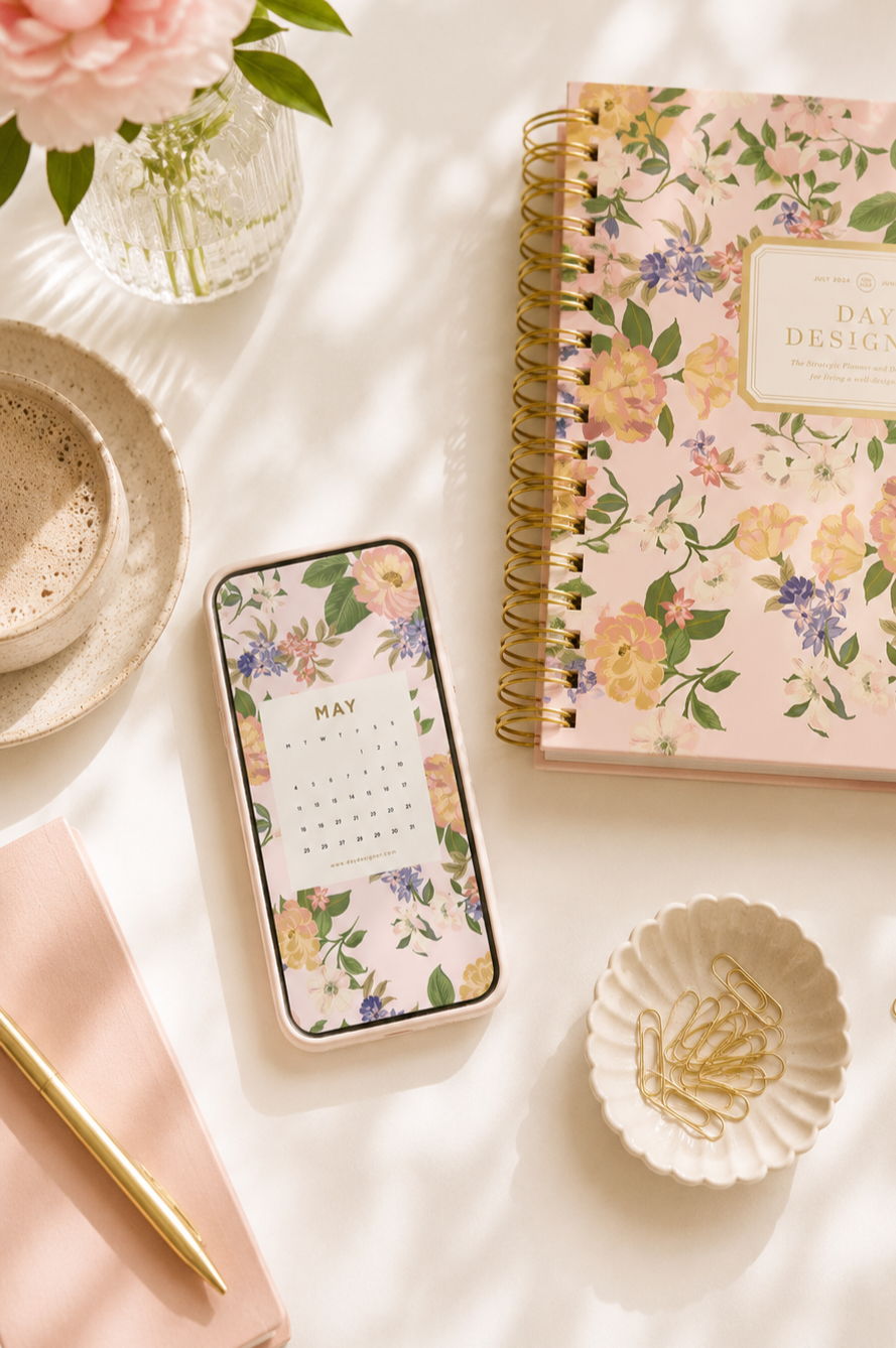 may 2026 mobile digital wallpaper in pretty pink floral pattern, beige background, dish with gold paperclips, day designer planner, stationery, coffee, vase with pink flowers