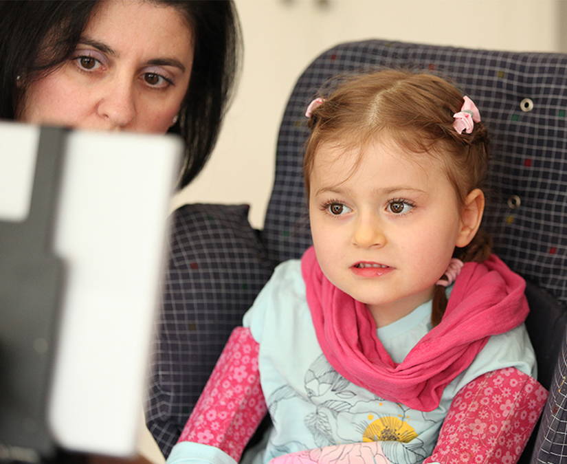 Mother and daughter using a Tobii Dynavox device for a trial 