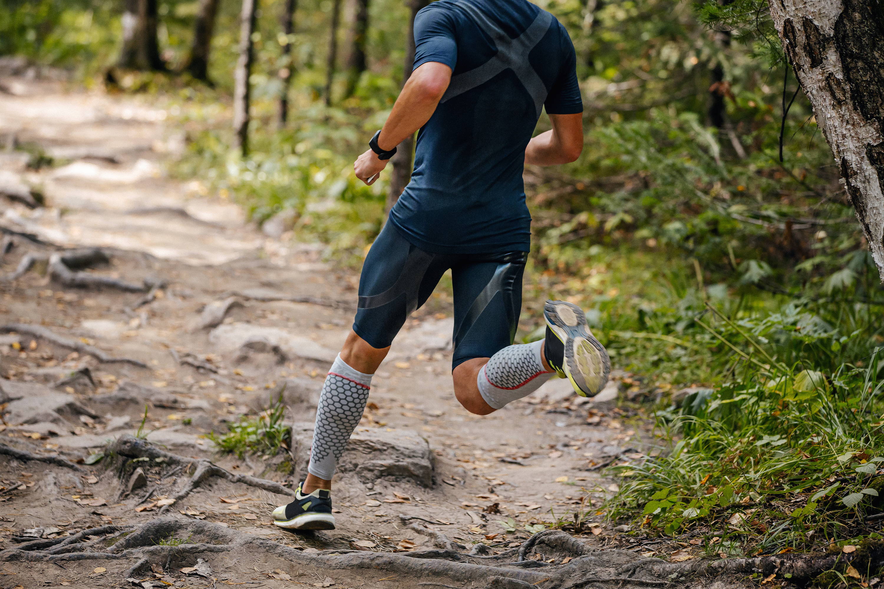 Man running on a hike, man wearing compression gsarments while exercising
