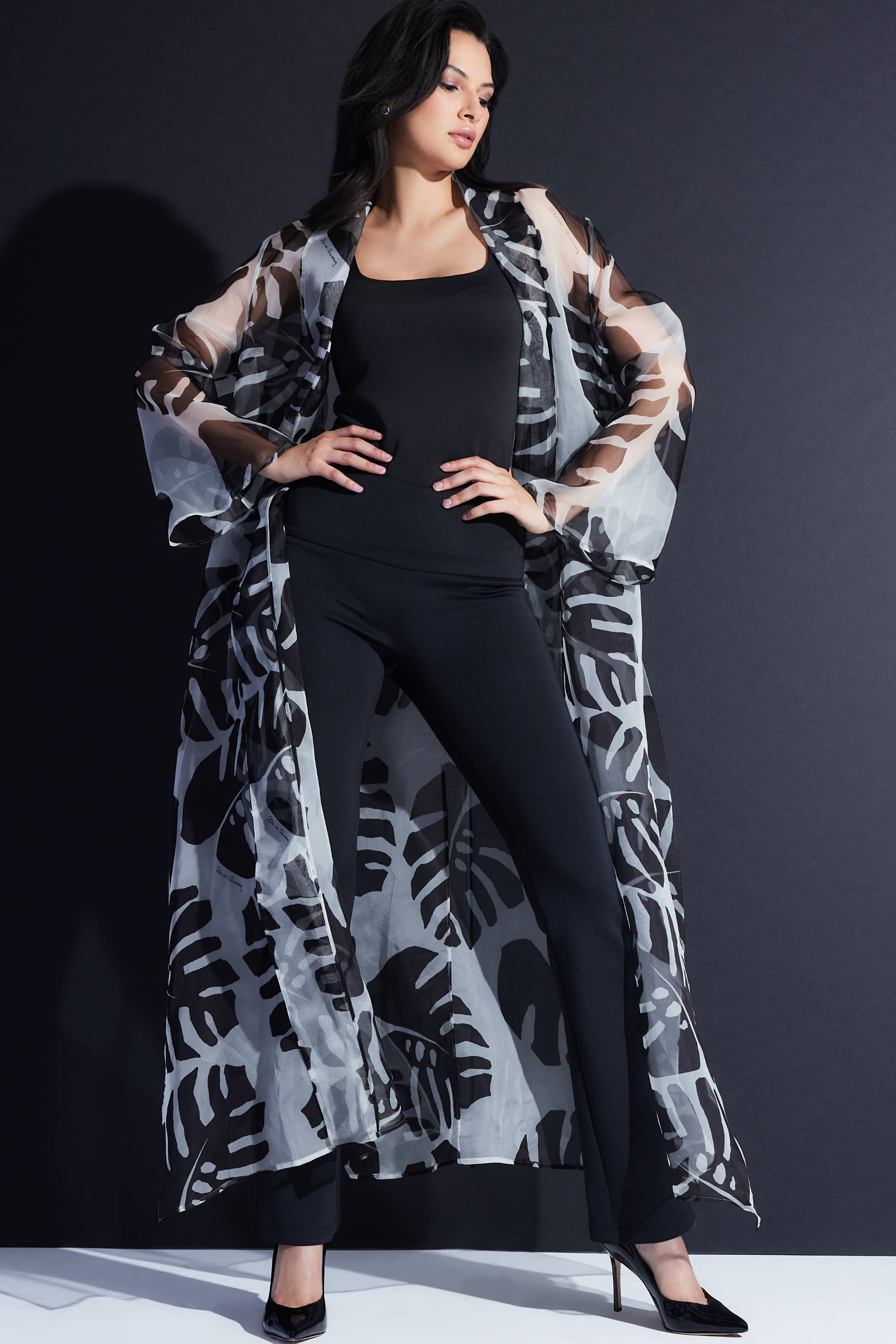 Woman wearing black and white palm printed silk organza duster over black italian stretch cotton tank top and pants by Ala von Auersperg