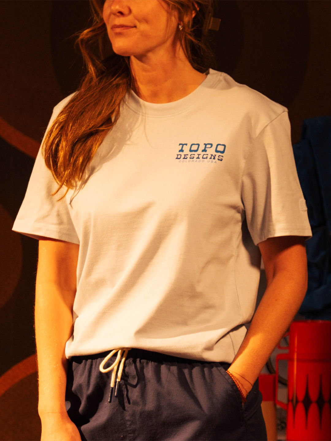 Person wearing a light blue t-shirt and dark shorts, standing in profile.