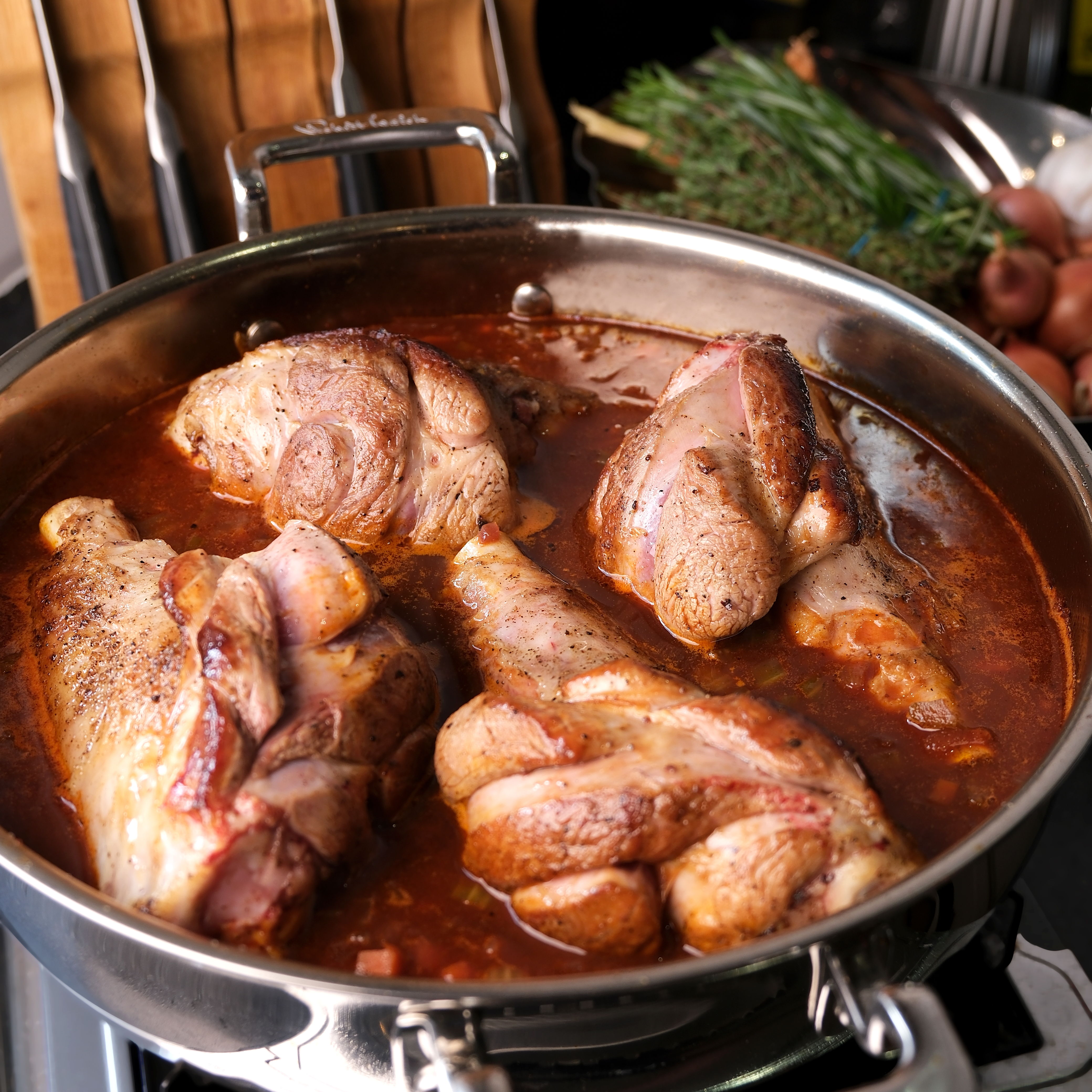 Braised lamb cooking in a 316 Series Low Casserole with herbs and sauce.