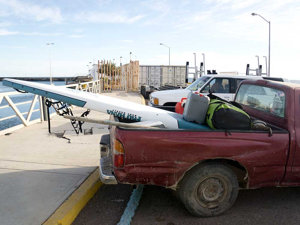 A pickup truck with a paddlebaord in the tray