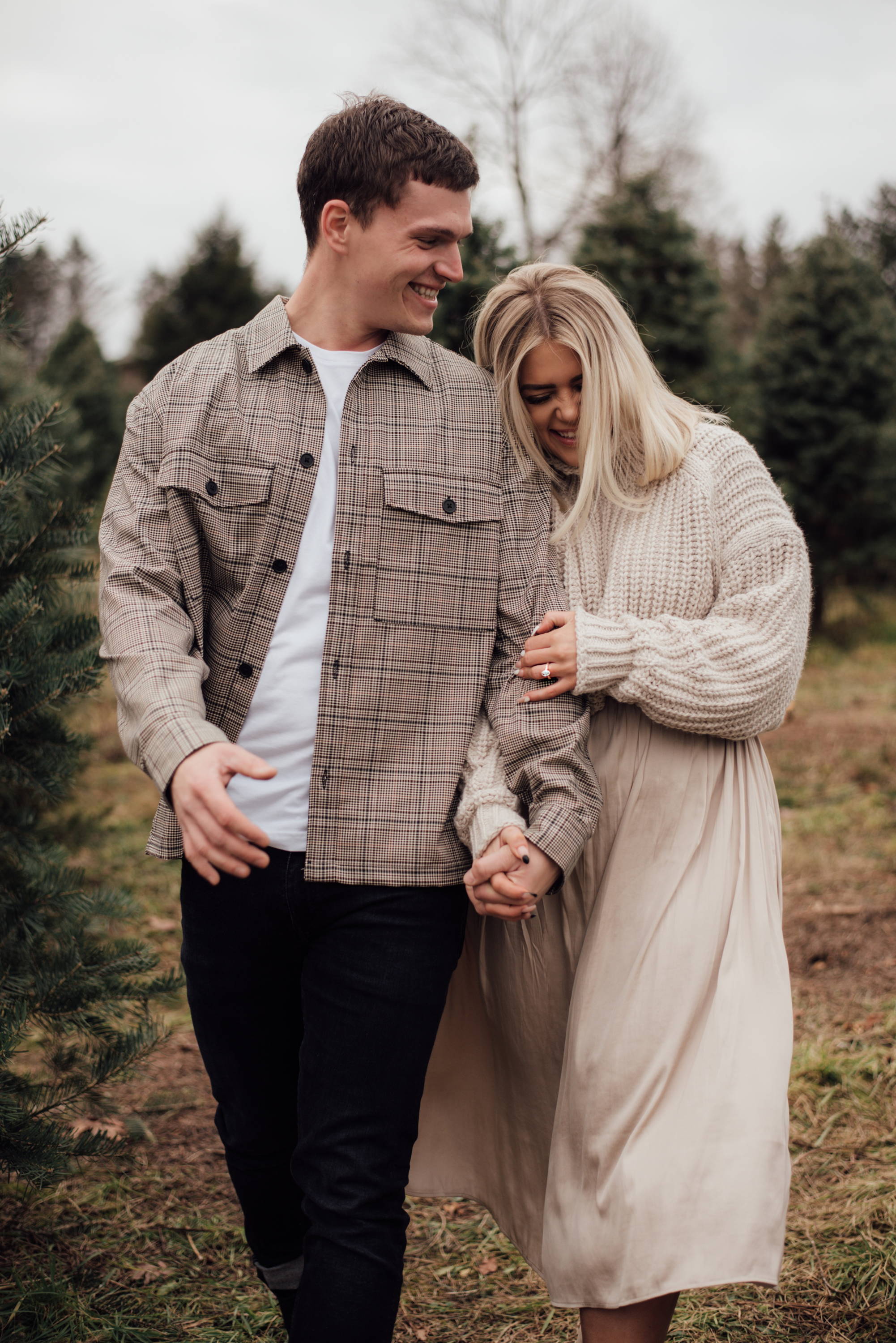 Henne Engagement Ring Couple James & Kelsey Smile and Laugh at a Christmas Tree Farm