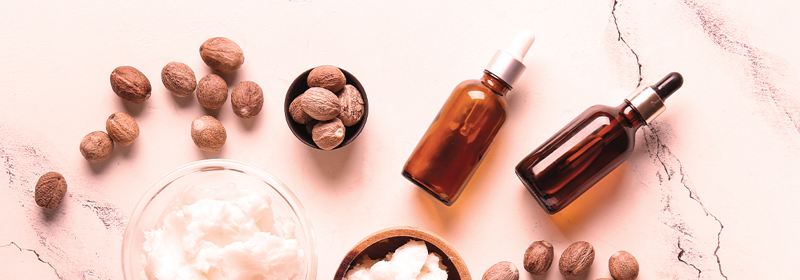 Bottles of oils and nuts on a marble surface.