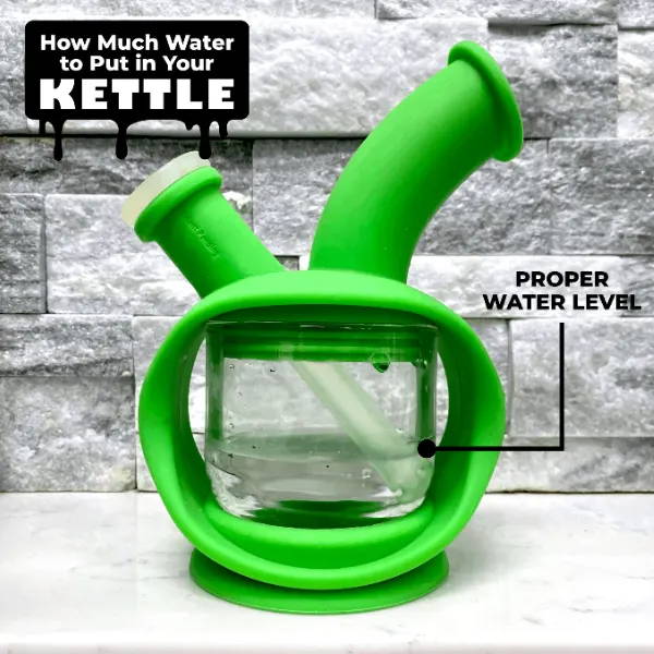 A green Ooze Kettle bong is shown filled with water. There is a black arrow that says FILL LINE pointing at the water level.
