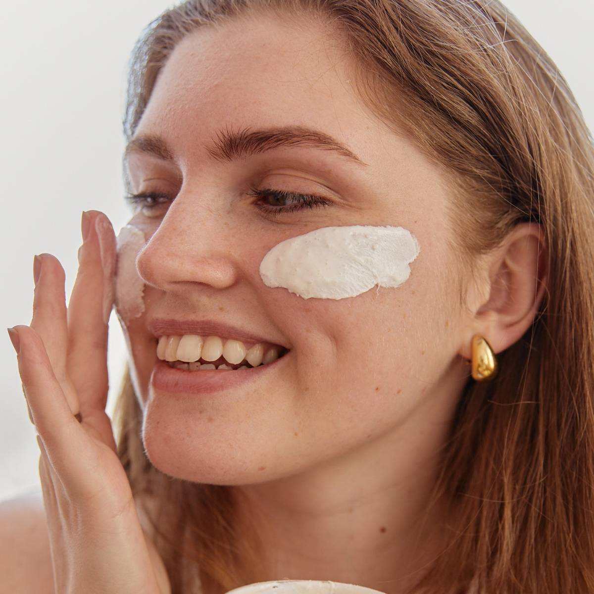 Model applying face cream on face