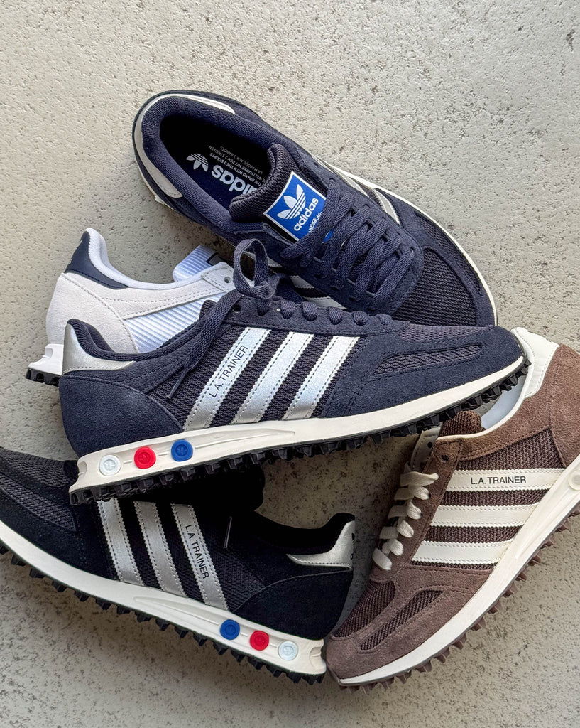 A stack of various Adidas sneakers in different colors.