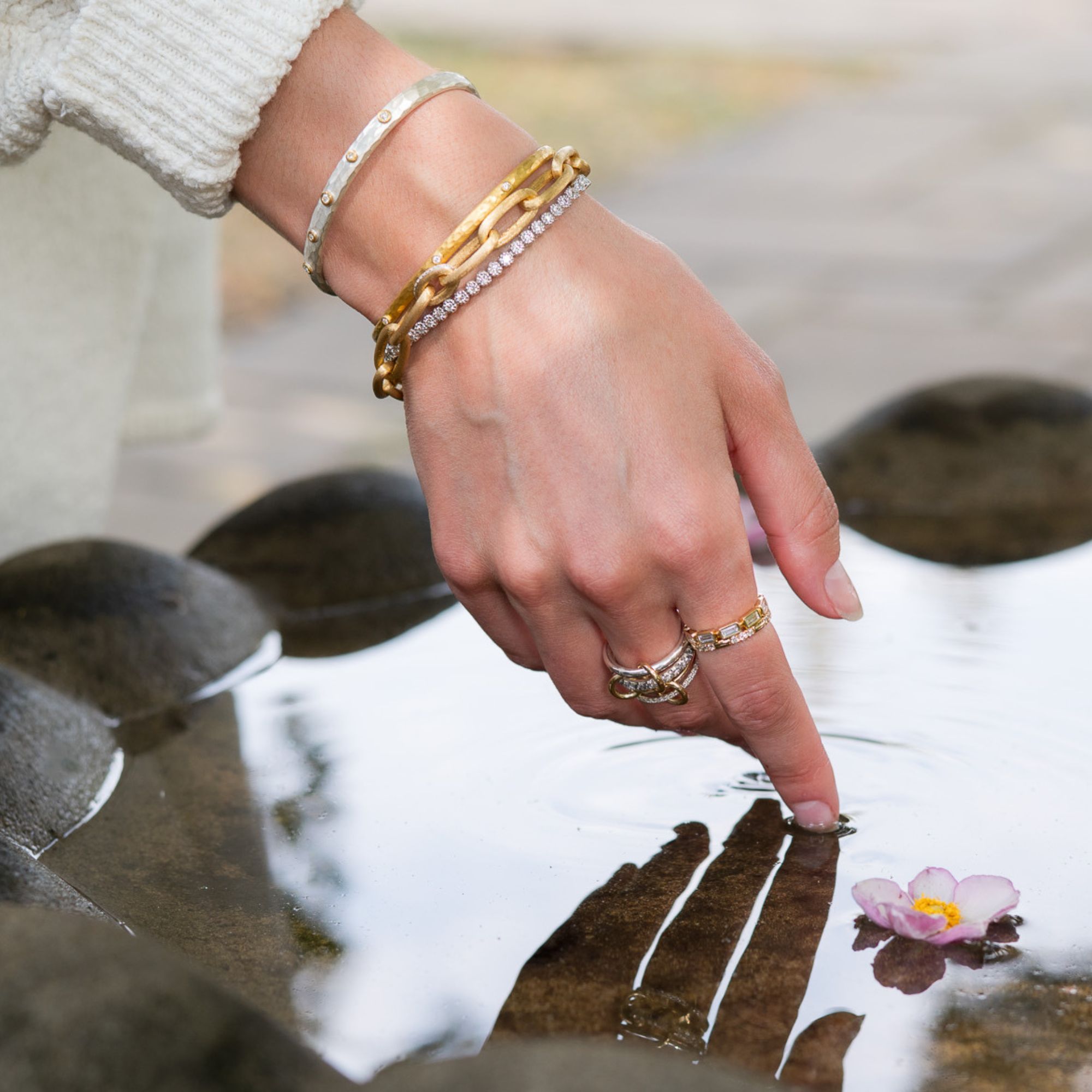 bracelets on a wrist with hand touching water