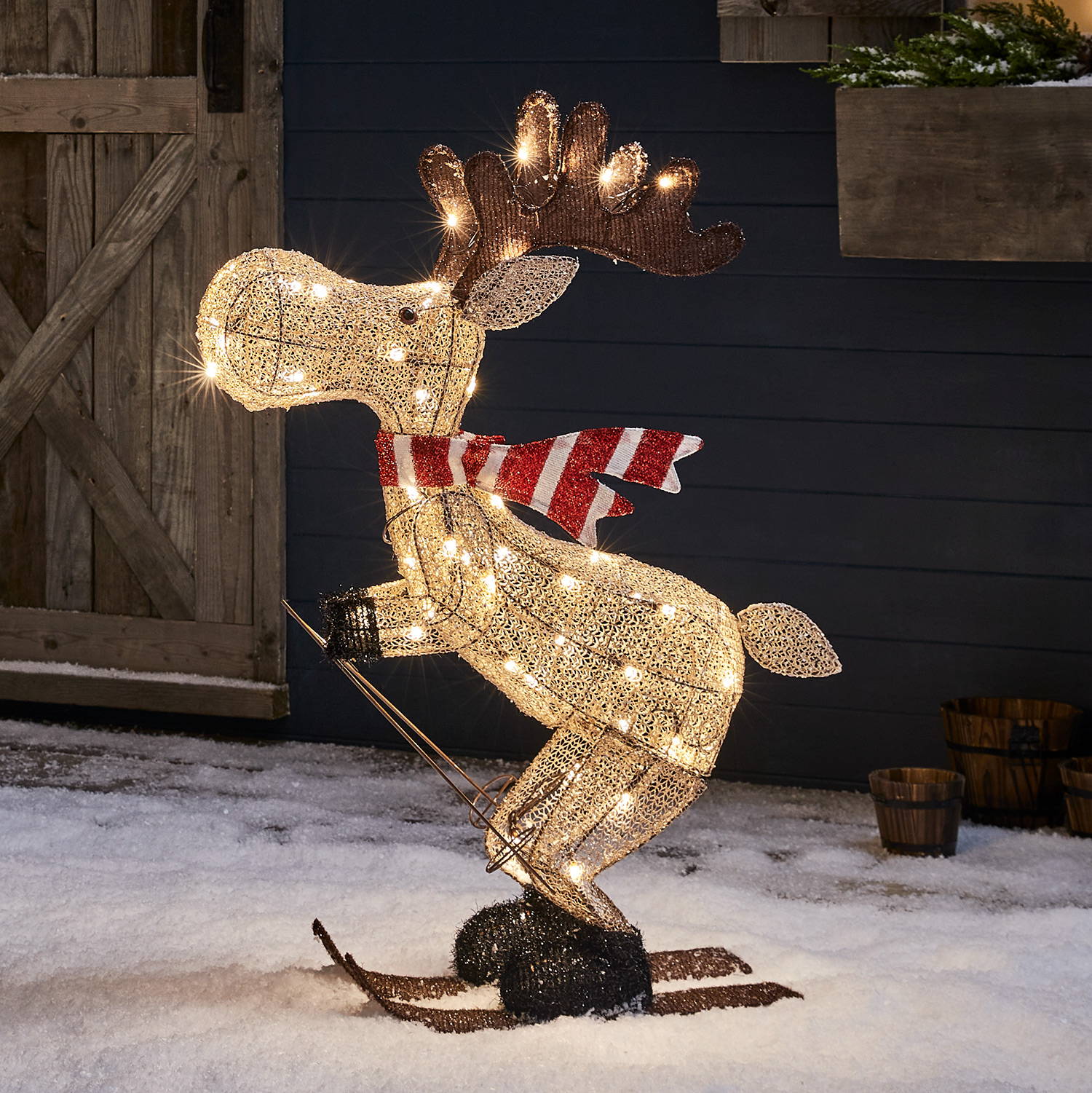 A light up skiing moose Christmas figure in a snowy setting.