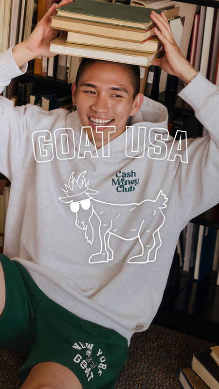 Smiling person in a hoodie holding books with a goat illustration.