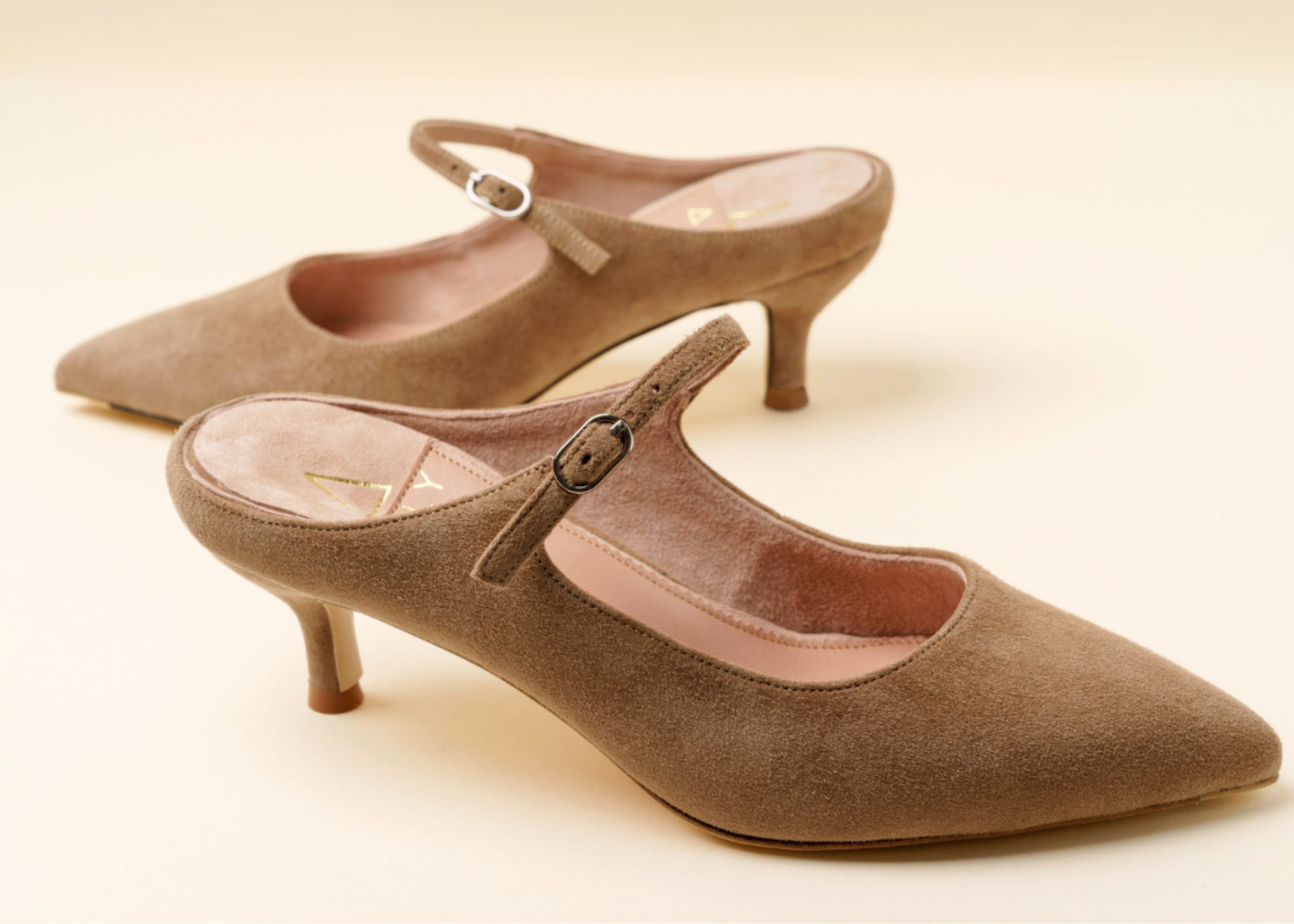 Brown suede slingback heels with a pointed toe and small heel.
