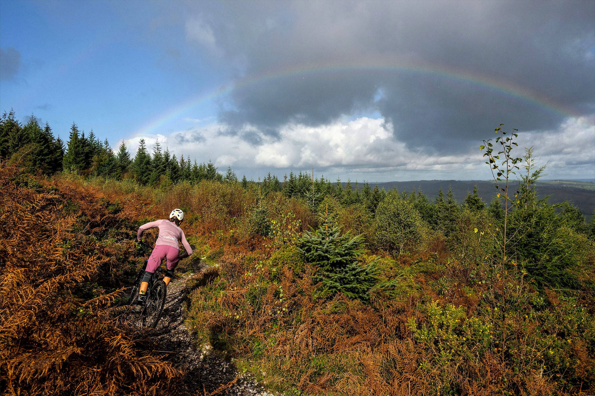 Amelia riding in front of rainbow