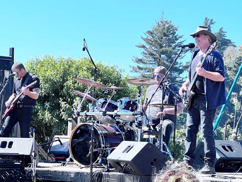 A guitarist, Bass player and Drummer in the band West of Nowhere playing live at the Salmon BBQ 