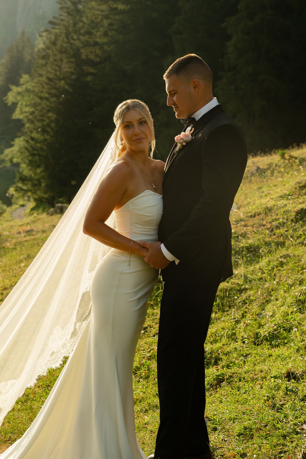 Bride and groom posing together in a scenic outdoor setting.