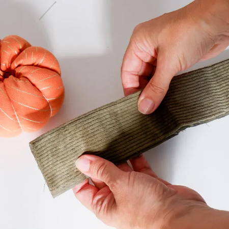 A green fabric strip folded in half for the stem of the fabric pumpkin