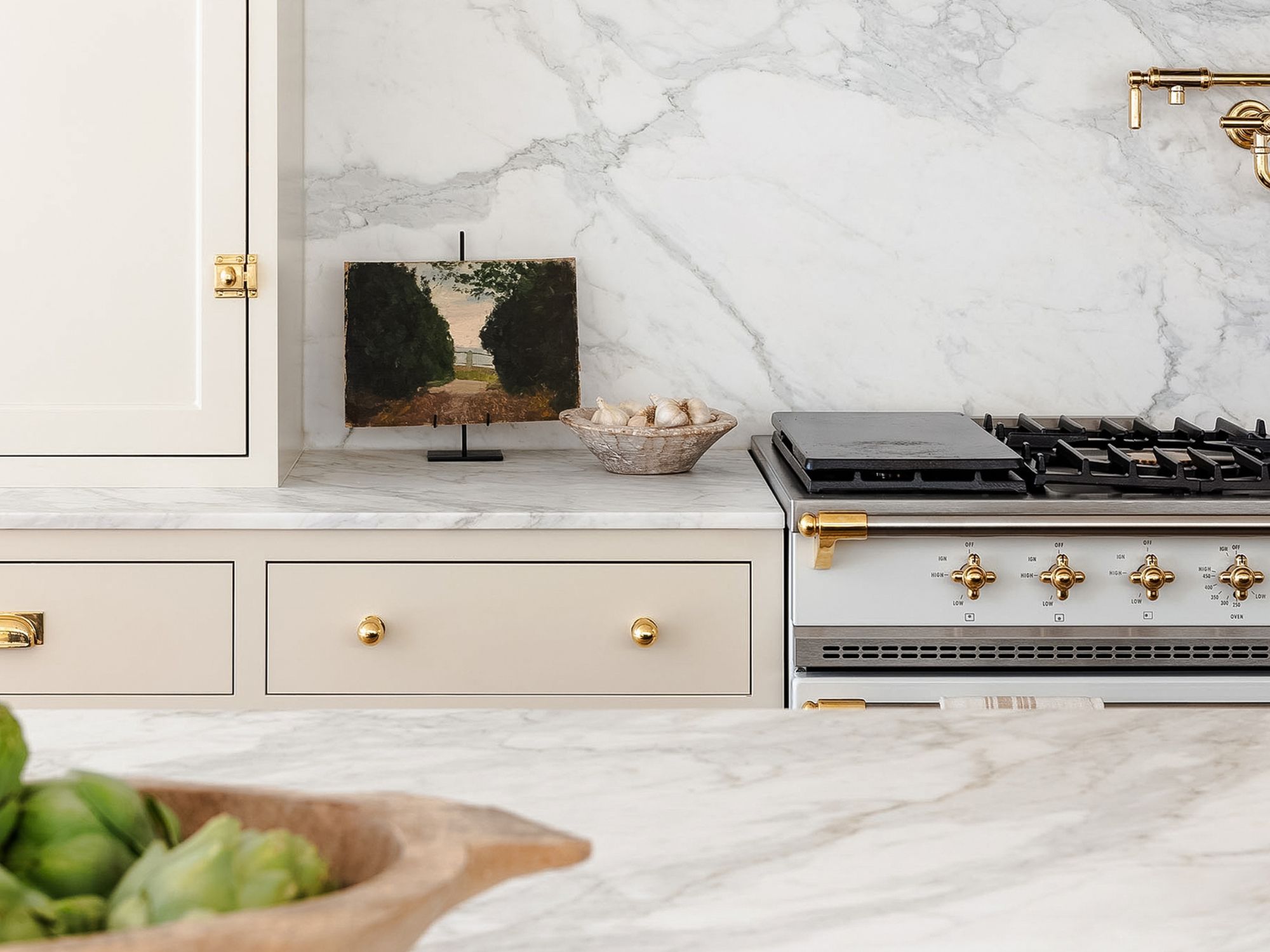 studio mcgee kitchen with marble worktops, neutral units and brass hardware