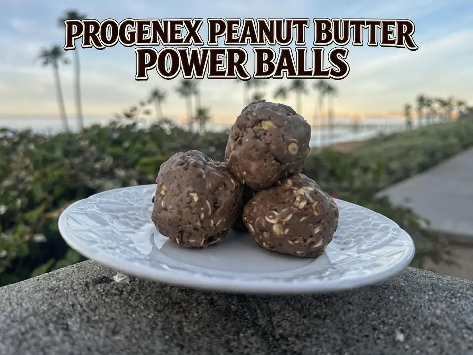Progenex peanut butter power balls on a plate against a sunset background.