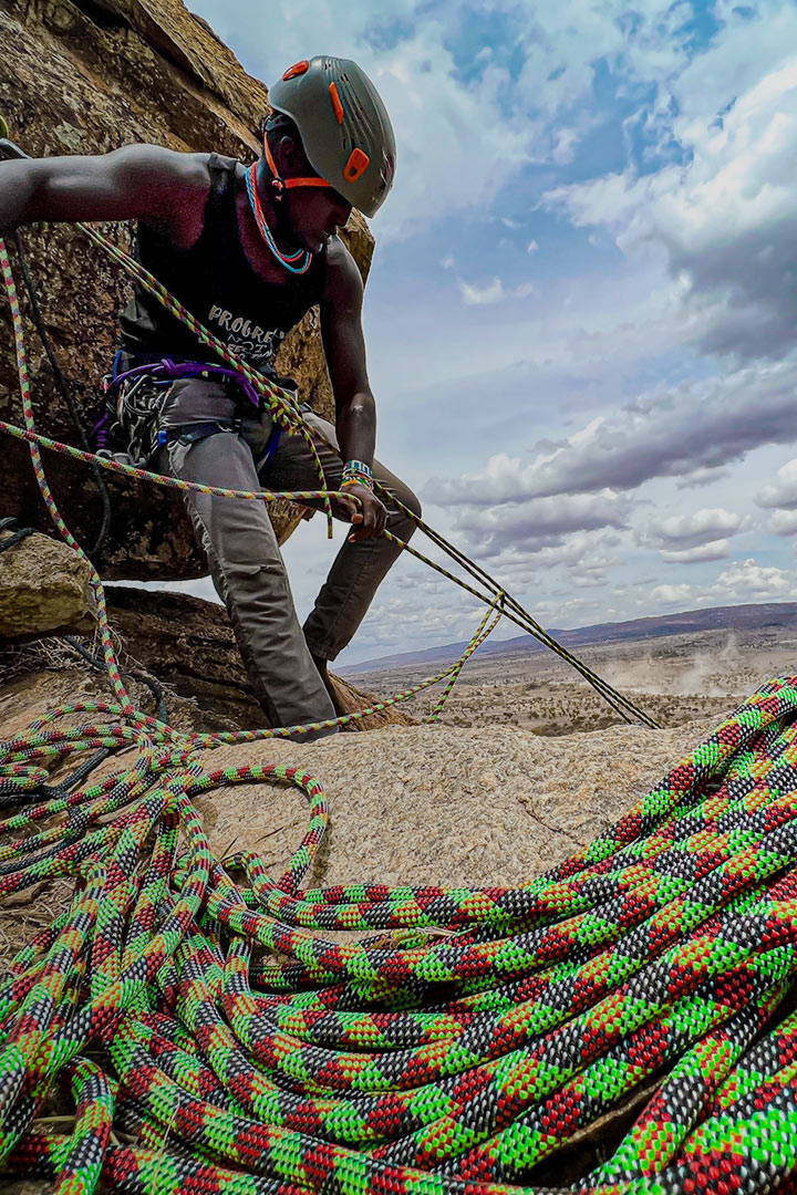 Rock climber on top of rocks with Kenya special edition rope