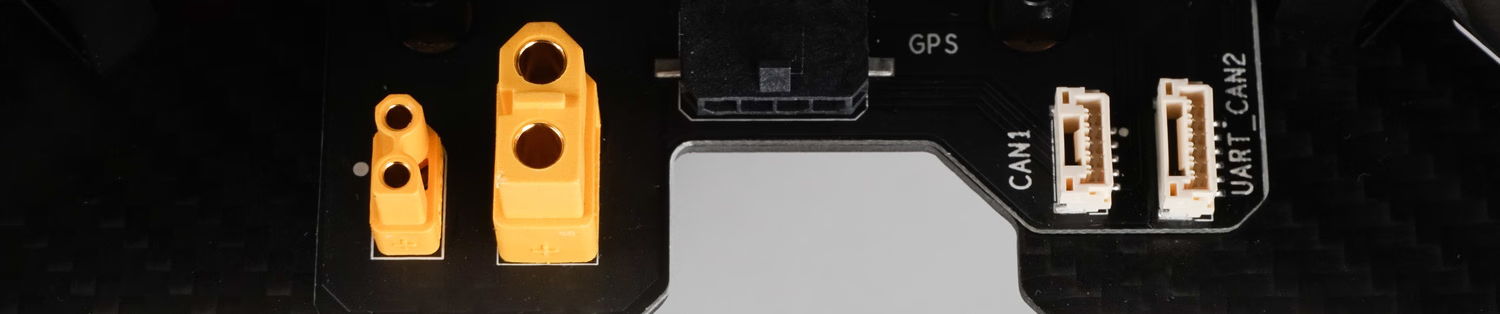 Two orange and white electrical connectors on a dark background.